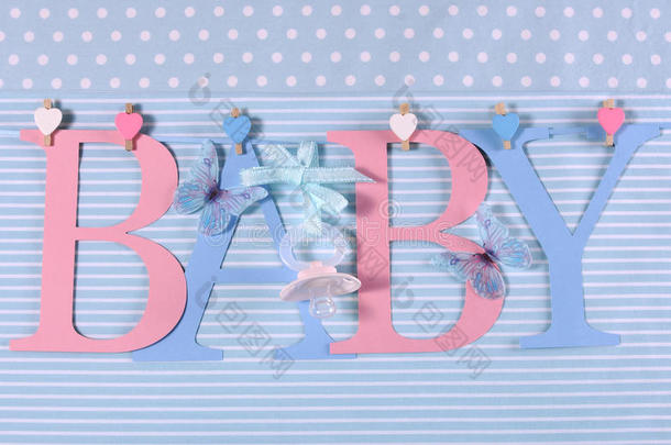 粉色和蓝色主题的婴儿彩旗字母挂在一条线上的钉子上