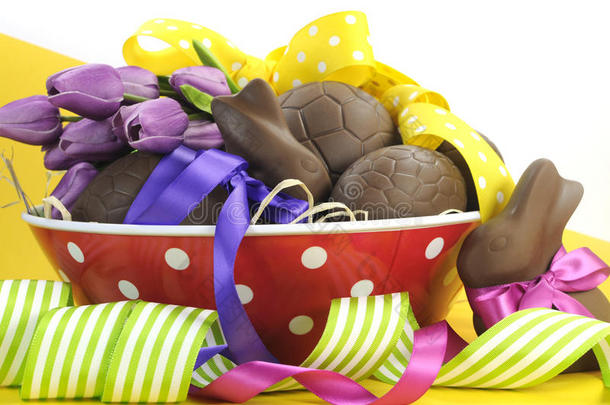 复活节快乐巧克力复活节彩蛋和兔子兔子篮，红色圆点碗中有彩色圆点和条纹丝带
