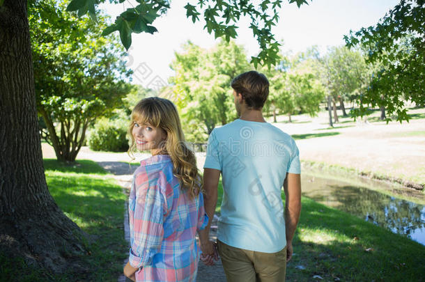 可爱的情侣手牵手在公园散步