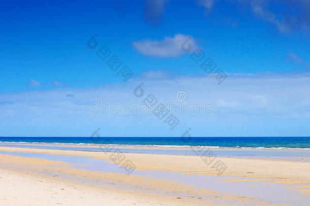 美丽的开阔的海滩，夏天有蓝天