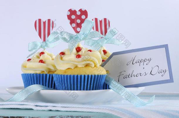 父亲节快乐明亮欢快的红白蓝装饰纸杯蛋糕，上面有心形装饰和礼品标签
