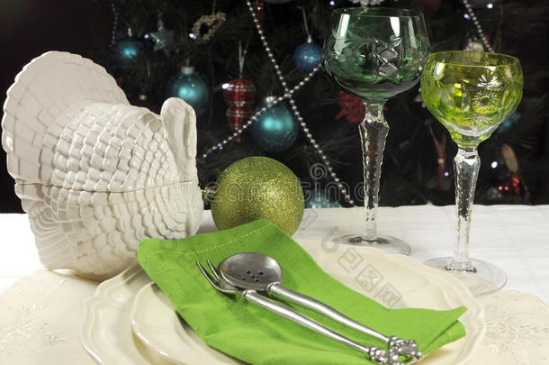 圣诞树前摆着漂亮的圣诞桌，配以绿色水晶酒杯