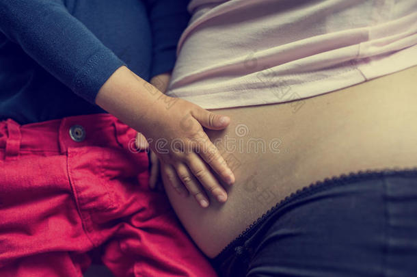 孩子抱着妈妈怀孕的肚子