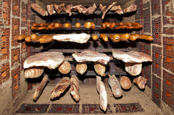 传统食物。烟熏肉挂在家庭烟熏房里