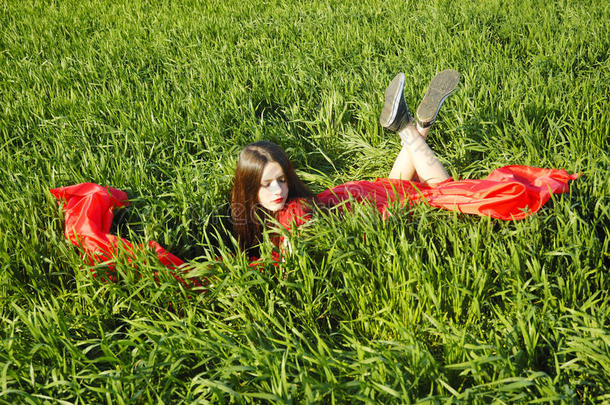 穿着<strong>红裙子</strong>的年轻女士躺在球场上