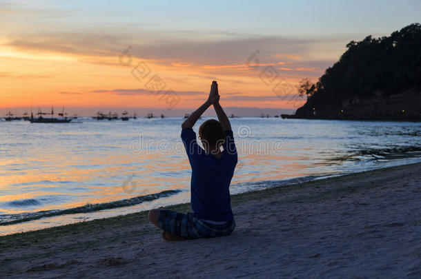 夕阳下<strong>做瑜伽</strong>的年轻人剪影