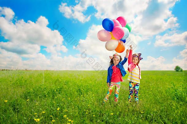 带着气球的孩子们<strong>在</strong>春天的<strong>田野上</strong>散步