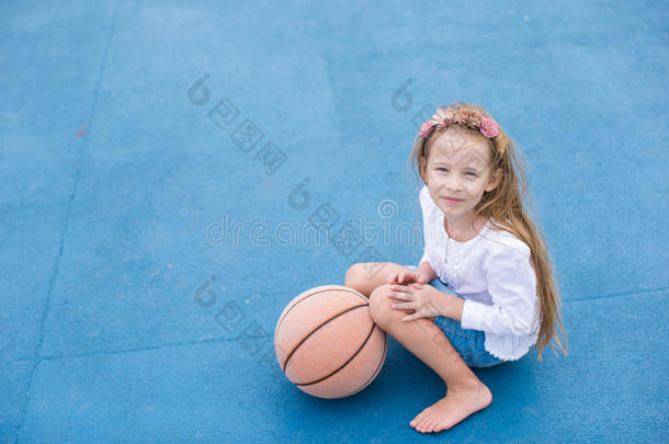 在室外球场上打篮球的小女孩