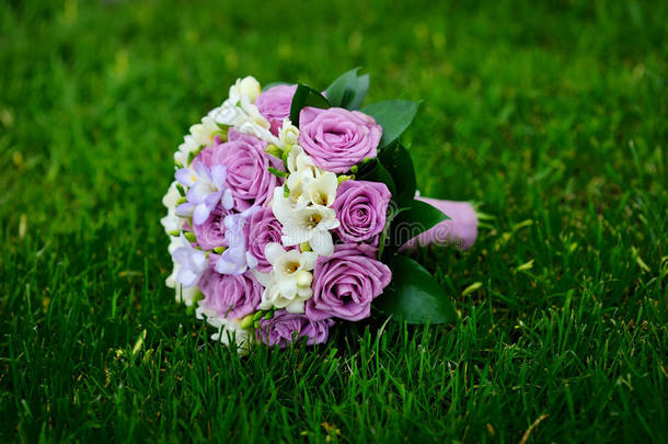 美丽的婚礼花束躺在草地上