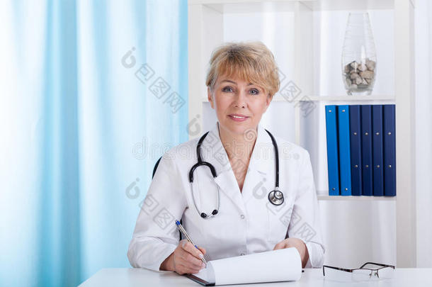 医生穿着实验室外套，听诊器在做笔记
