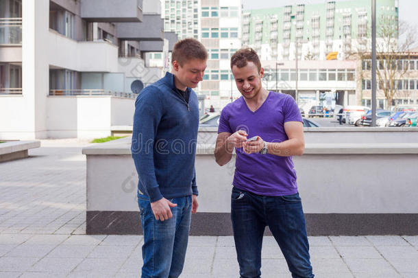 男游客用手机向男游客问路