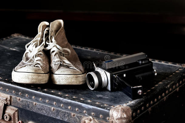 手提箱上有运动鞋和摄像机