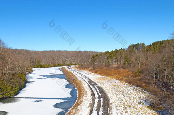 寒风凛冽的道路，沿着结冰的河流行驶。