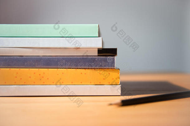 桌子上的书。没有标签，空白的书脊和铅笔