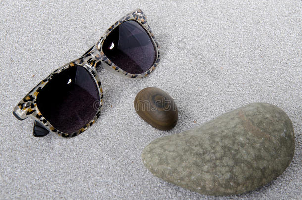 沙滩上的墨镜和鹅卵石