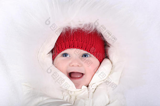 笑嘻嘻的<strong>宝宝</strong>，穿着白色雪地服，戴着红色针织<strong>帽子</strong>