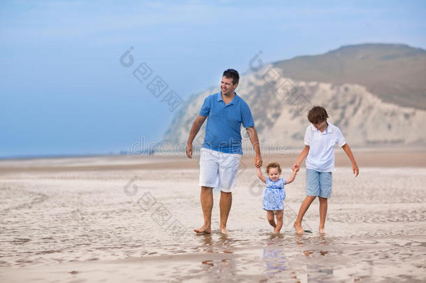 年轻活跃的父亲和孩子们在海滩上玩耍