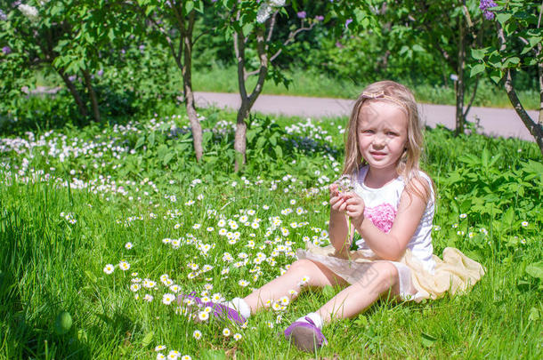 <strong>快乐</strong>的小女孩在绿色的空地上采花