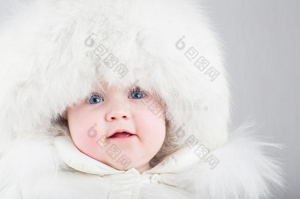 特写一张戴着白色毛皮帽子的<strong>可爱婴儿</strong>的肖像