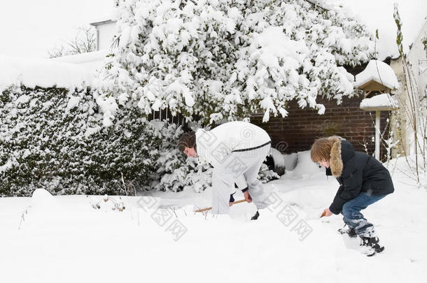 父子俩在花园里一起<strong>铲雪</strong>