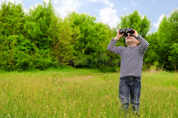 小男孩用望远镜扫视树林
