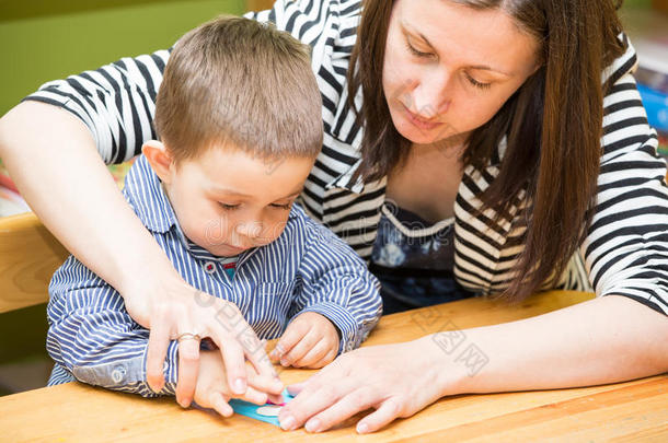 幼儿园里，妈妈和孩子们一起在幼儿园用铅笔画画