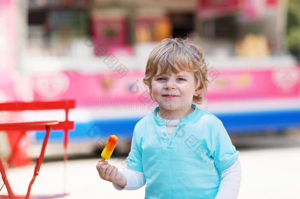 快乐的小男孩在夏天吃着五颜六色的冰淇淋