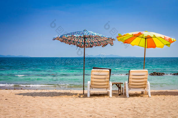 沙滩上有<strong>沙滩伞</strong>、日光浴椅和边桌