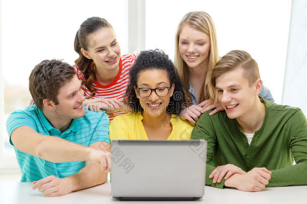 学生们微笑着看着学校里的笔记本电脑