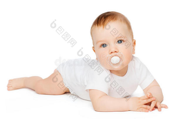 微笑的婴儿躺在地板上，嘴里叼着假人