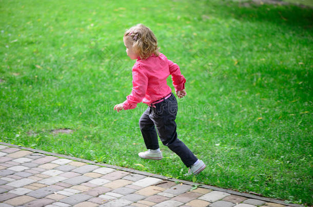 有趣的小女孩在绿草上奔跑
