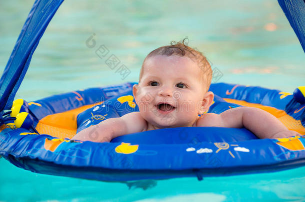 快乐的婴儿在游泳池里玩耍，坐在婴儿车里