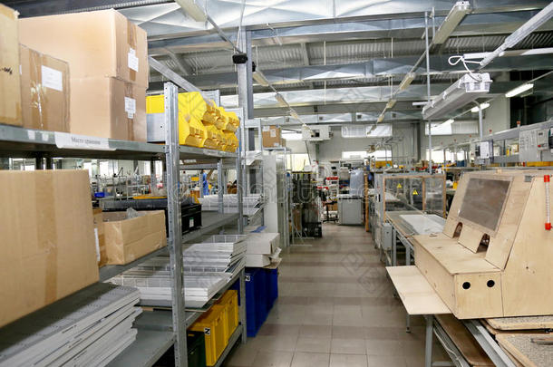 现代化工厂仓库上的机械现代化厂房，彩色塑料包装盒，金属货架上的个人防护用品