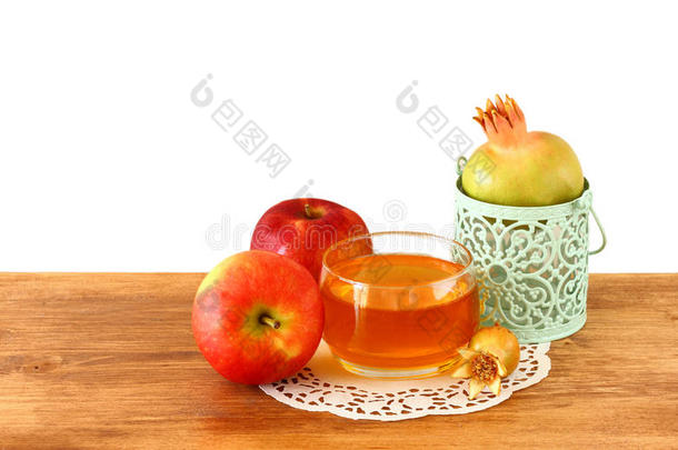 rosh hashanah概念-苹果蜂蜜和石榴放在木桌上。孤立的