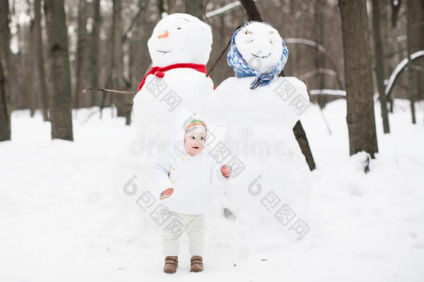 冬天公园里，一个有趣的<strong>小宝宝</strong>在雪人旁边