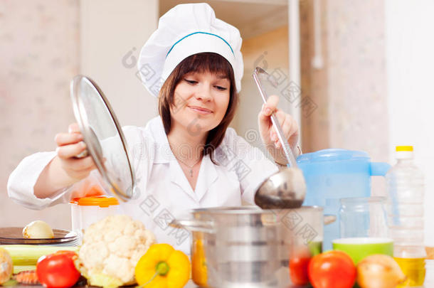 戴斗篷的女人用勺子做饭