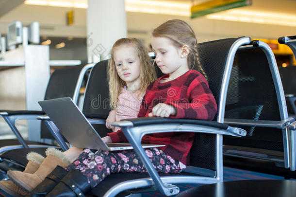 孩子们在机场等着的时候拿着笔记本电脑