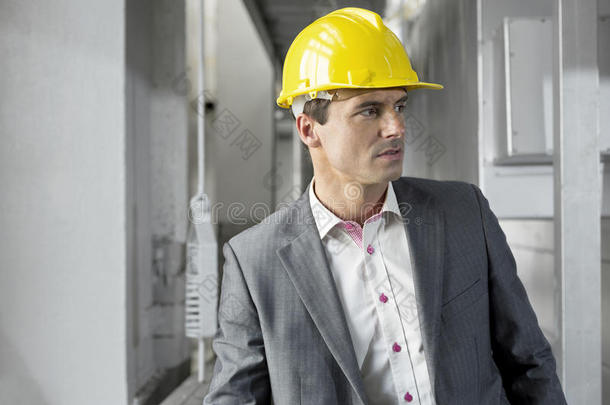 戴着安全帽的年轻男主管在工业中看得远远的