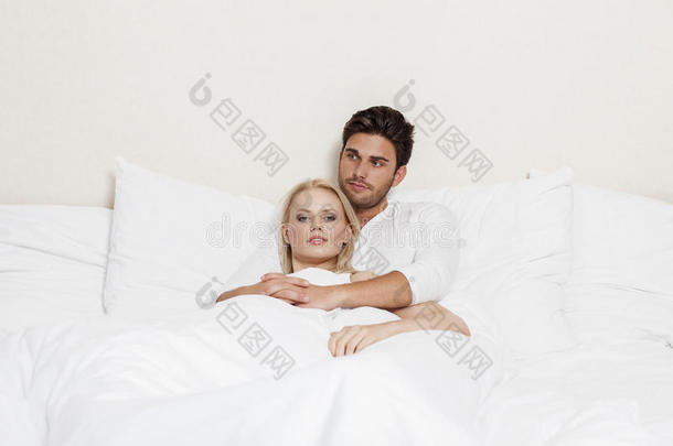 可爱的年轻夫妇在床上放松