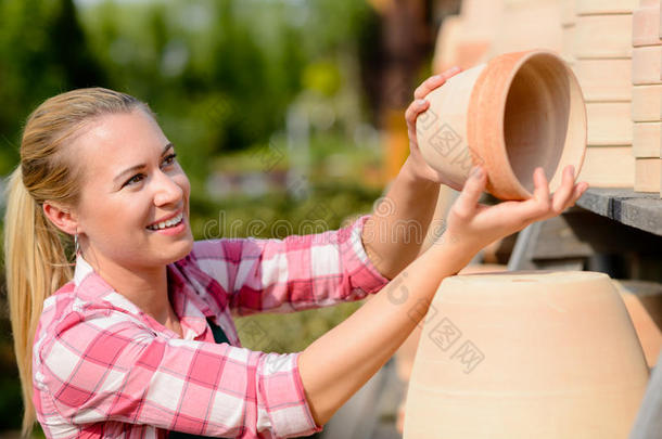 花园中心女人放陶罐架子