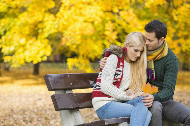 秋天，可爱的<strong>年</strong>轻人在公园长椅上拥抱害羞的女人