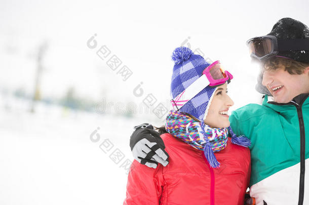 一对相爱的年轻夫妇在雪地里看着对方