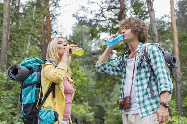 <strong>年</strong>轻的徒步旅行夫妇在森林里喝能量饮料