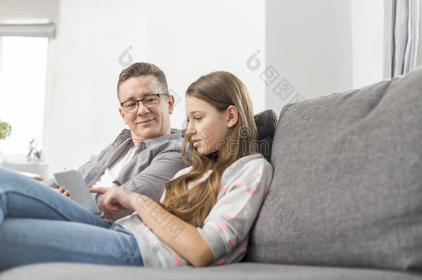 父女俩在<strong>家</strong>沙发上用<strong>数码</strong>平板电脑