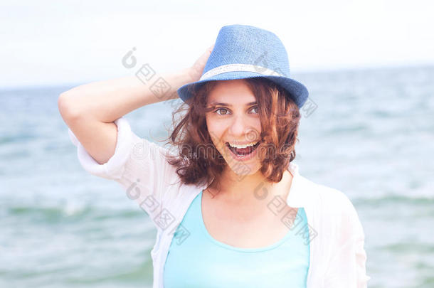 美丽的女孩戴着帽子，背景是大海，柔和的焦点