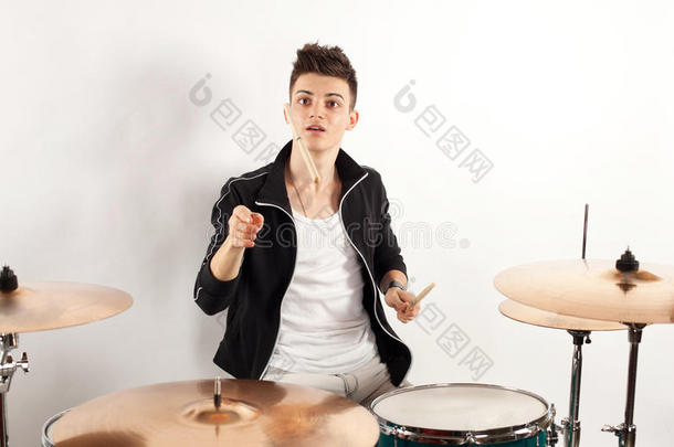 富于表现力的年轻鼓手用鼓棍打鼓
