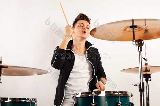 富于表现力的年轻鼓手用鼓棍打鼓