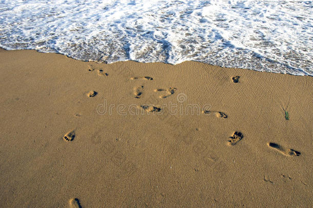 沙滩沙滩上赤脚的脚步和海浪