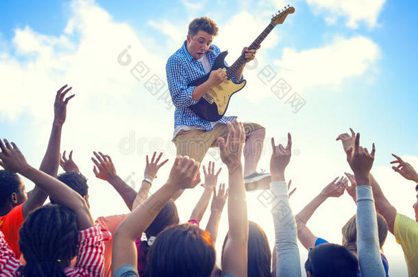 一个年轻人拿着吉他在狂喜的人群中表演