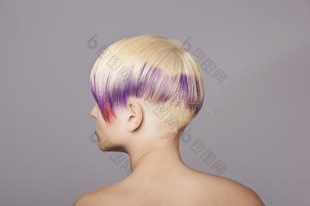金发女孩涂着紫罗兰色颜料。美丽的女人